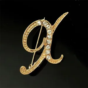 Vista detallada de un elegante broche con la letra A dorada e incrustaciones de diamantes
