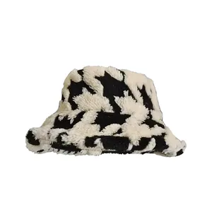 Cappello a secchiello invernale in peluche con motivo pied de poule bianco e nero.