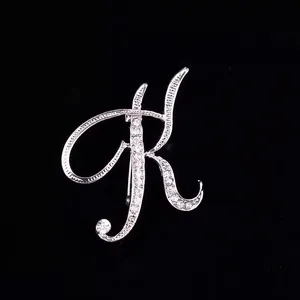 Primer plano detallado de un broche letra K de diamantes de imitación plateados