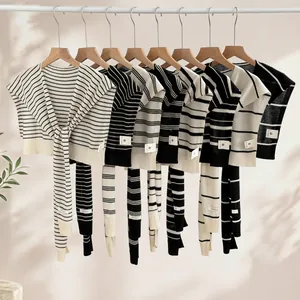 Juego de chales de punto de rayas 100% Tencel colgados en perchas de madera natural