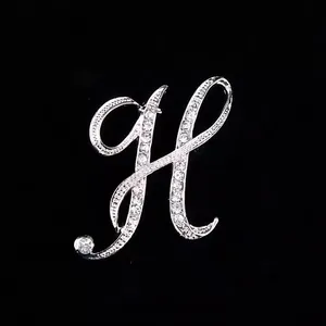 Elegante broche con forma de letra H plateada y detalles de diamantes de imitación