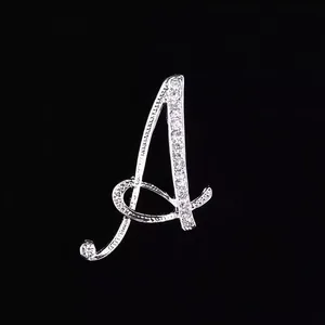 Primer plano de un elegante broche con la letra A plateada y pedrería brillante para mujer