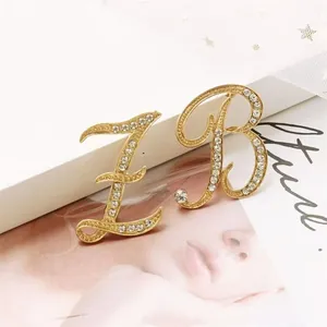 Elegantes broches de letras cursivas con pedrería dorada para accesorios de mujer