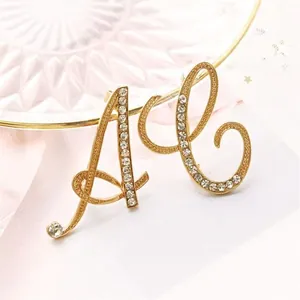 Elegante broche de letra dorada con diamantes de imitación para accesorios de mujer.