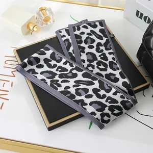 Detailed macro view of a leopard print skinny scarf styled on a luxury display board