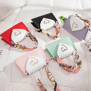 Detailed view of mini square bags in various colors with heart buckles and scarves