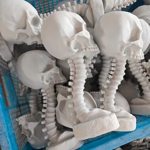 Detail shot of unpainted skull planters with spine stands in a storage crate