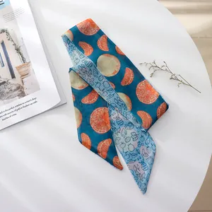Detail view of a vintage blue silk scarf with vibrant orange fruit slice patterns.