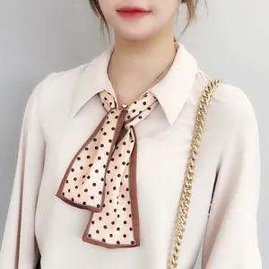 French style polka dot silk scarf ribbon tied around a white blouse collar