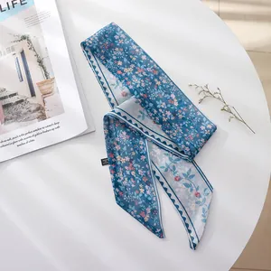 Detailed view of a blue floral chiffon hair scarf with a delicate wave edge pattern.