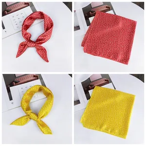 Detailed view of red and yellow polka-dot silk scarves in knotted and square styles.