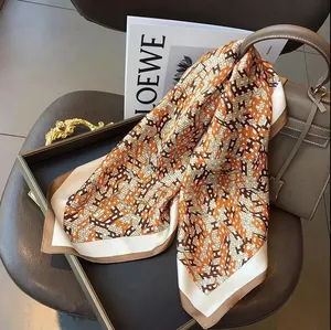 Elegant detail showing the geometric H pattern on a 70cm square faux silk scarf
