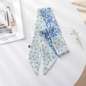 Close-up of a blue floral chiffon hair ribbon with French retro style on white table
