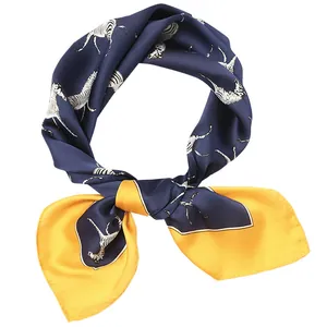 Macro detail view of a navy blue and yellow square silk scarf with zebra patterns