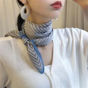 Close-up of a striped blue and white silk neckerchief tied in a bow around a neck.
