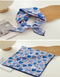 Detailansicht eines blauen Baumwoll-Halstuchs mit Herzmotiven und Spitzenbordüre