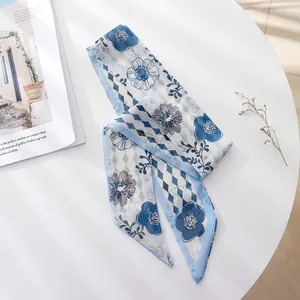 Detailed view of the blue floral chiffon hair scarf placed on a white round table