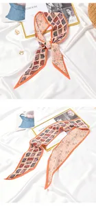 Detail view of pink pleated skinny scarf with floral and geometric patterns on white satin.