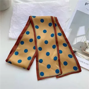 Close-up of a French retro skinny silk scarf with blue polka dots on a gold background