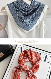 Close-up detail of elegant blue and orange paisley pattern silk-like neck scarf
