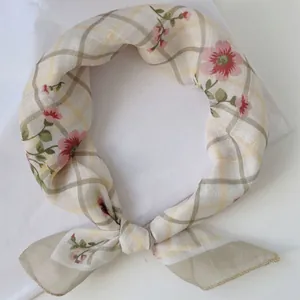 Vista dettagliata della trama floreale e a quadri vintage su un foulard quadrato annodato