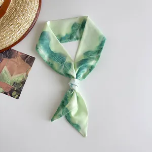 Detail showing the artistic oil painting pattern on a narrow mint green silk scarf ribbon