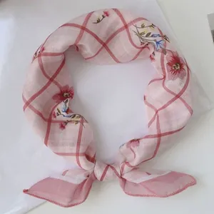 Primo piano di sciarpa a quadri rosa con fiori e un elegante nodo decorativo