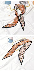 Close-up detail of pleated silk scarf with orange floral and geometric patterns for women