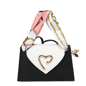 Elegant mini square handbag with black-white contrast design and a golden heart buckle