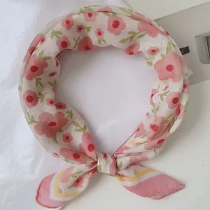 Primo piano di un foulard con stampa floreale che mostra delicati fiori rosa