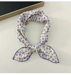 Detailed view of a floral cotton linen scarf featuring small blue flower patterns