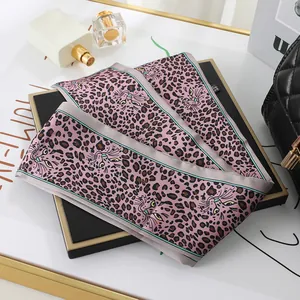 Close-up of pink leopard print skinny silk scarf with cat face design for bags