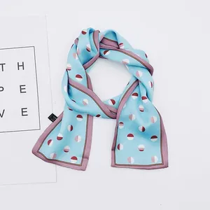 Detail of French retro light blue skinny scarf with red and white polka dots.