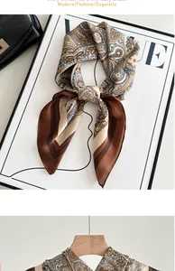 Macro detail of elegant brown paisley imitation silk scarf draped on a wooden hanger