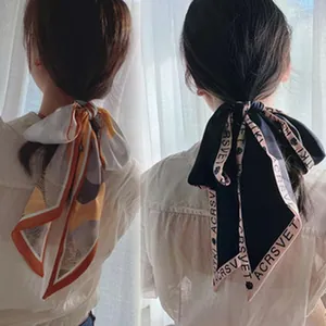 Close-up of elegant French vintage silk scarves used as hair ribbons on models.