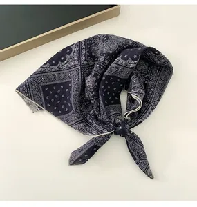 Detailed shot of a dark blue paisley pattern cotton linen small square scarf tied in a knot