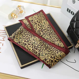 Close-up detail of a double-layer leopard print satin scarf on a professional display board