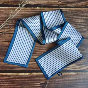 Detailed view of a blue and white striped French hair ribbon on a dark wood background