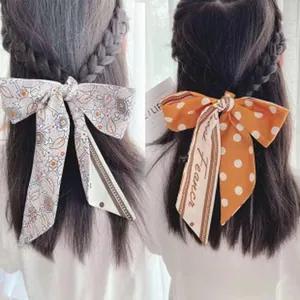 Detail showing French vintage long ribbon hair tie with floral and polka dot patterns