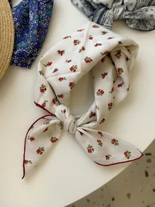 Detail view of a vintage floral cotton linen bandana tied in a stylish decorative knot