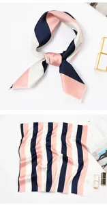Detailansicht des pink-navy gestreiften Seidenschals, flach liegend und geknotet.