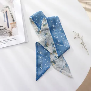 Close-up detail of blue floral and polka dot chiffon skinny scarf with foliage print