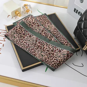 A detailed close-up showing the leopard print and feline pattern of this satin skinny scarf.