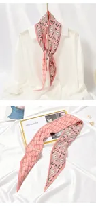 Close-up of pink pleated skinny scarf with geometric diamond pattern and Love print.