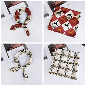 Elegant detail of small square silk scarves featuring pixel horse and golden chain patterns