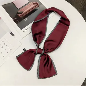 Detailed view of an elegant burgundy French silk hair ribbon with striped border
