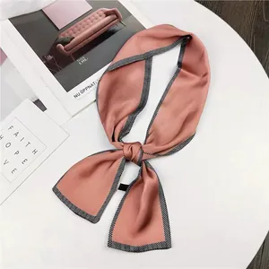 Detailed view of a dusty rose skinny silk scarf featuring a black and white chevron border