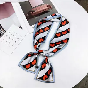 Detailed shot of a French vintage striped silk scarf featuring a vibrant red heart pattern