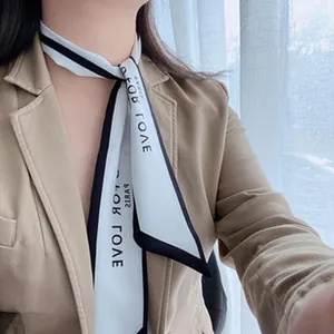 Close-up of a vintage French-style skinny white scarf with black edges