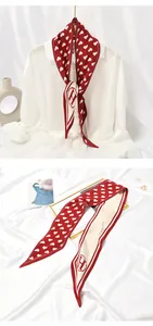 Detailed view of red pleated skinny scarf featuring white heart patterns and H logo